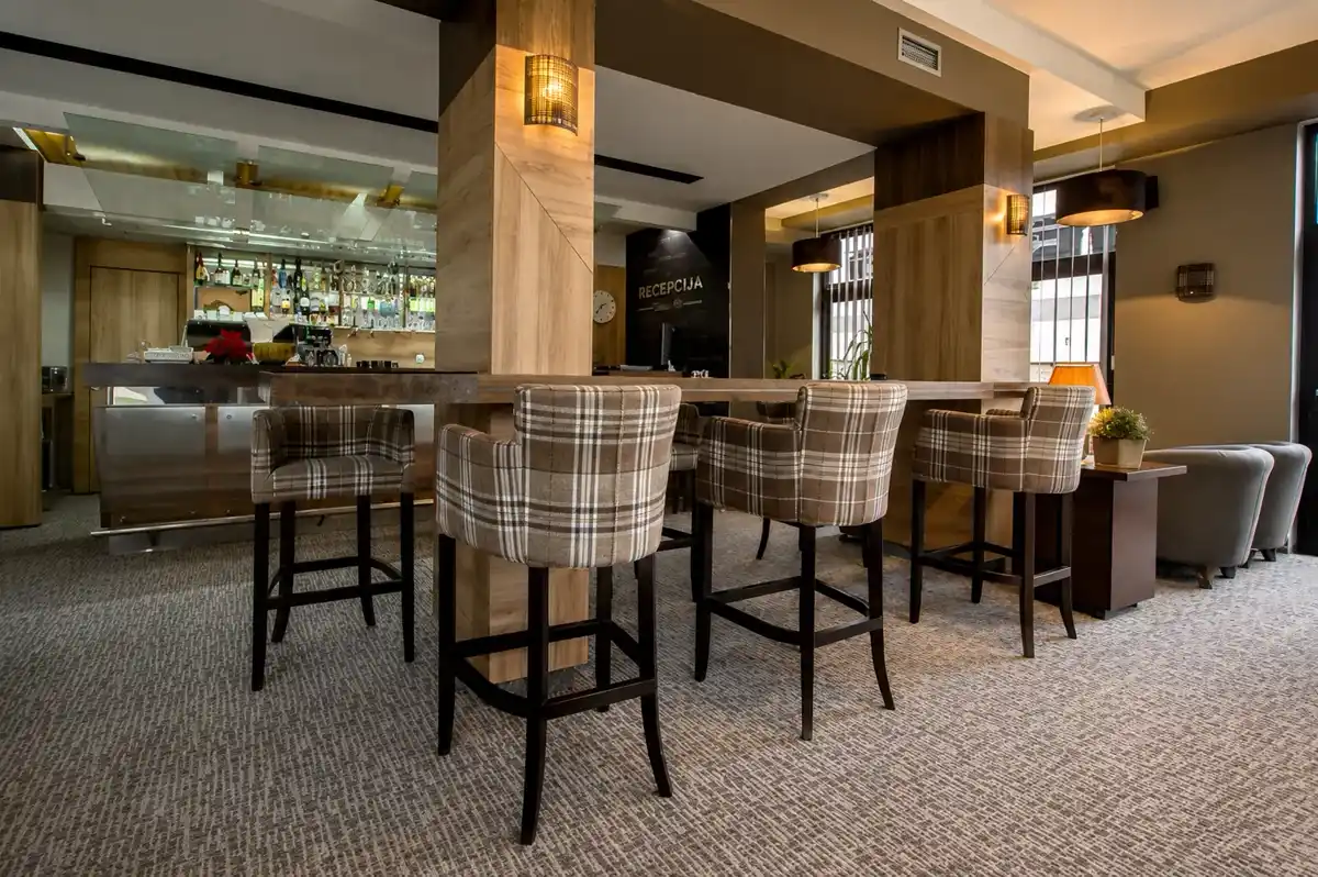 Hotel bar and reception area with high stools and timber panelling